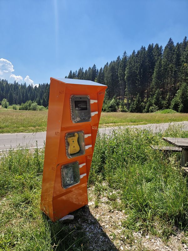 Naprava SOS Točka za klic v sili, nameščena na robu gorskega travnika